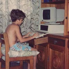 Léo criança, sem camisa, digitando no primeiro computador da família nos anos 90