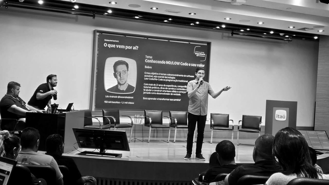Léo Andrade no palco do Itaú, de microfone na mão, falando para a plateia sobre no-code e low-code